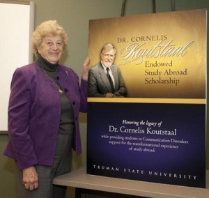 Murilyn Koutstaal poses with a poster celebrating the endowed study abroad scholarship created in honor of her late husband, Cornelis Koutstaal.