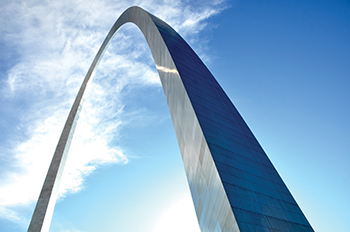 The St. Louis arch with blue sky and clouds behind it